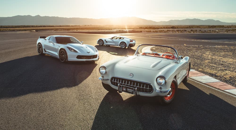 A white 1953 and two 2017 Chevy Corvettes are shown on at sunset. 
