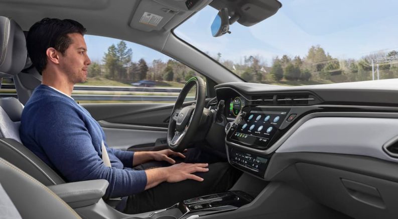 A person is shown using using the Super Cruise feature in a 2023 Chevy Bolt EUV on the way to an Chevy SUV dealership.