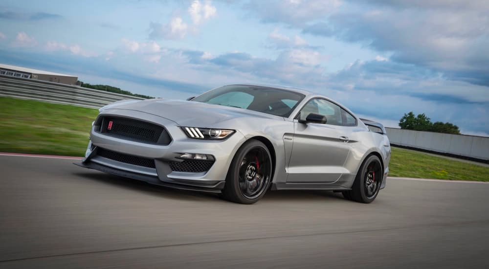 A silver 2020 Ford Mustang Shelby GT500 is shown from the side driving on a track.