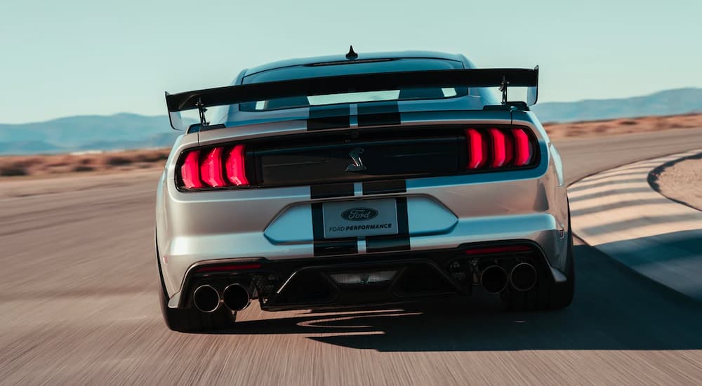 A silver 2022 Ford Mustang Shelby GT500 is shown from the rear on a race track.