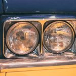 A close up shows the passenger side headlight on a blue 1969 used Cadillac DeVille.