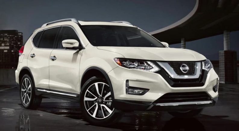 A white 2020 Nissan Rogue is shown from the front parked at night.