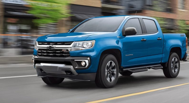 A blue 2022 Chevy Colorado Z71 is shown driving on a city street.