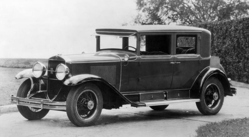 A 1928 Cadillac Sedan is shown from the side.