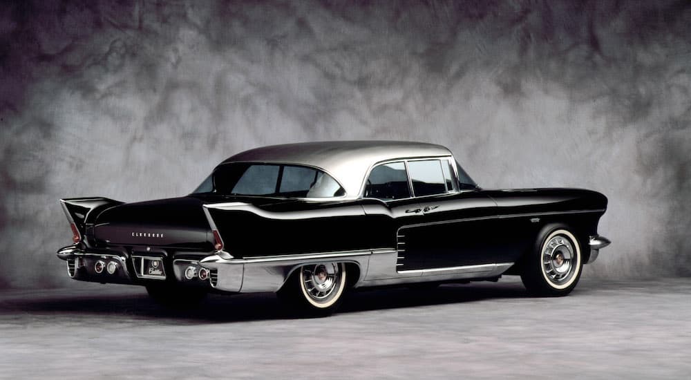 A black 1957 Cadillac Eldorado is shown from the rear at an angle after leaving a Cadillac dealer.