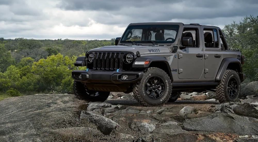 A grey 2022 Jeep Wrangler Unlimited Willys is shown from the front at an angle after leaving a dealer that has a used Jeep Wrangler for sale.