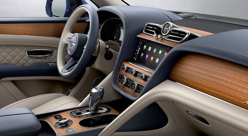 The black and brown interior of a 2023 Bentley Bentayaga Azure shows the center console and steering wheel.
