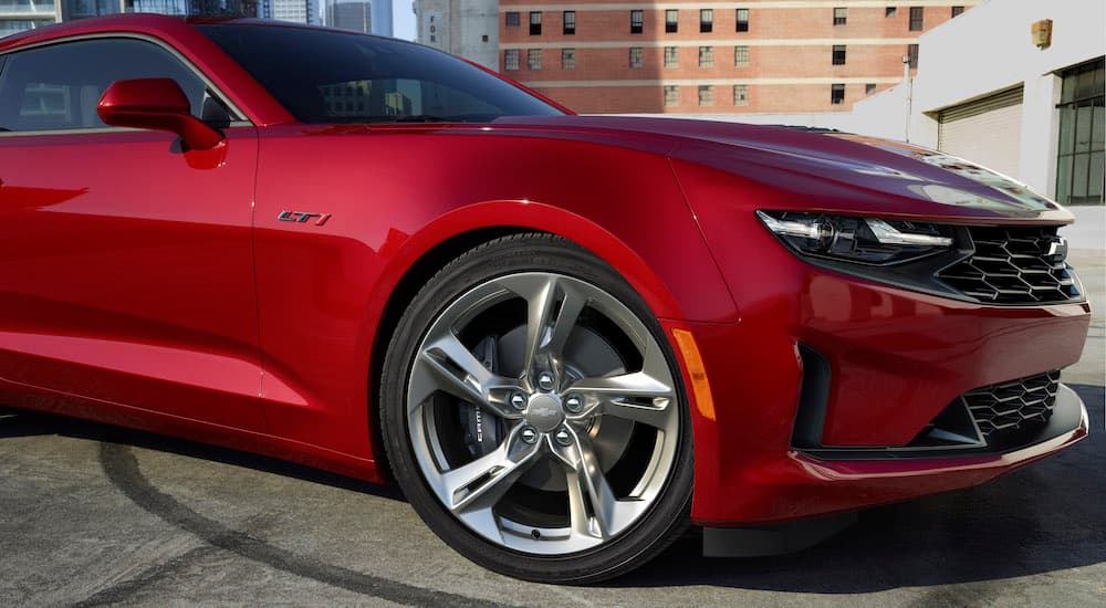 A close up shows the front passenger side of a red 2023 Chevy Camaro LT1.