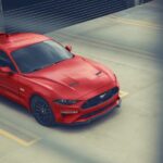 A red 2023 Ford Mustang GT is shown parked in a parking garage.