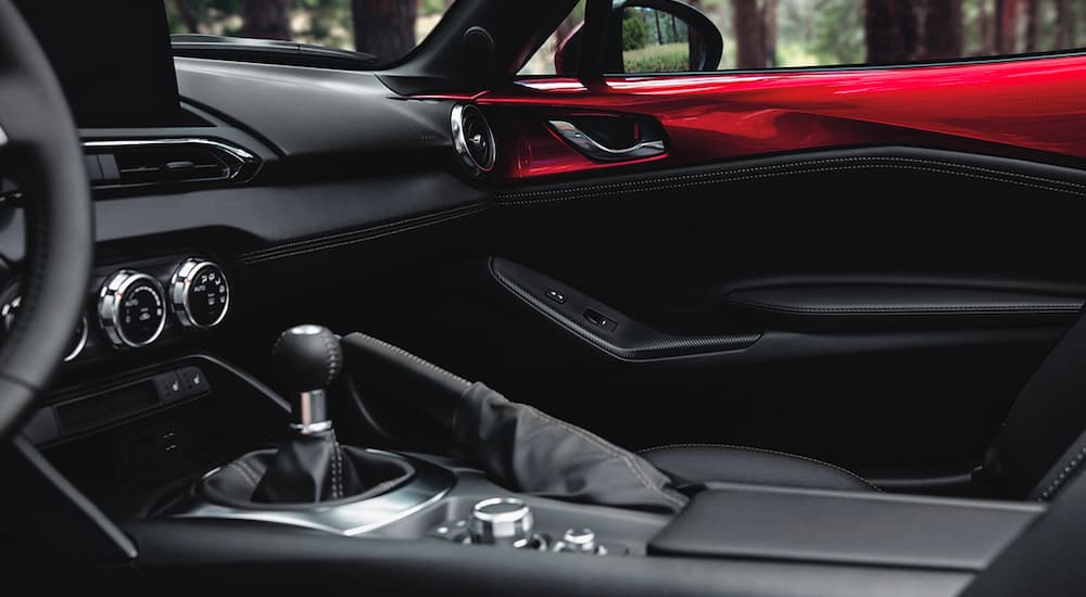 The black and red interior is shown in a 2023 Mazda MX-5 Miata.