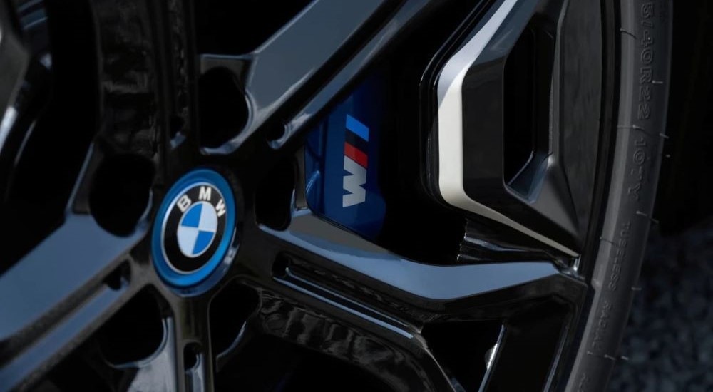 A close up shows the black rim and caliper on a 2024 BMW iX.