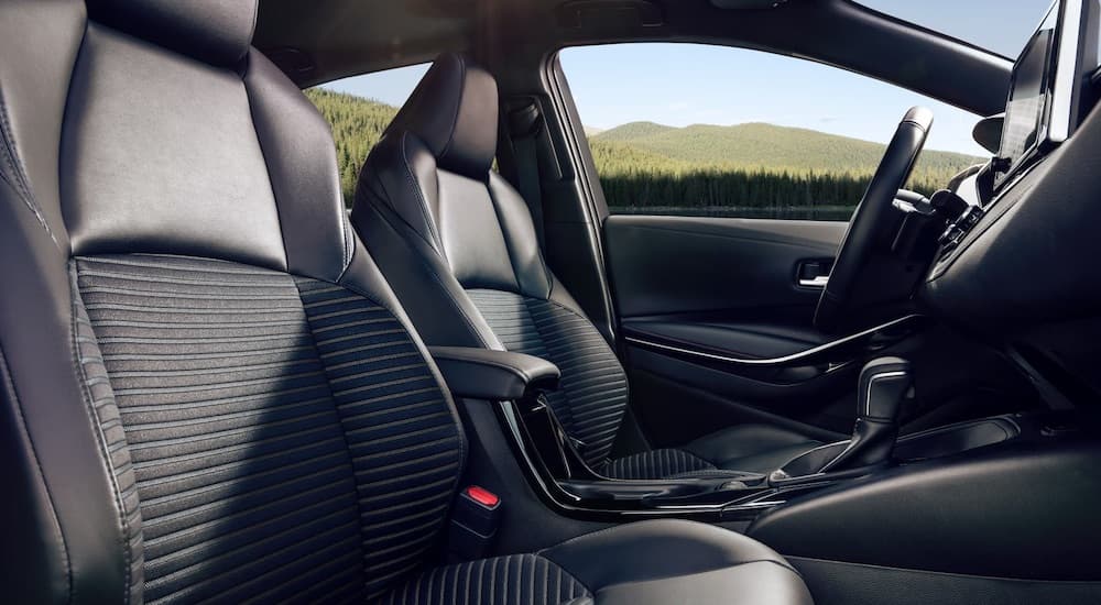 The black interior of a 2023 Toyota Corolla is shown from the passenger seat.