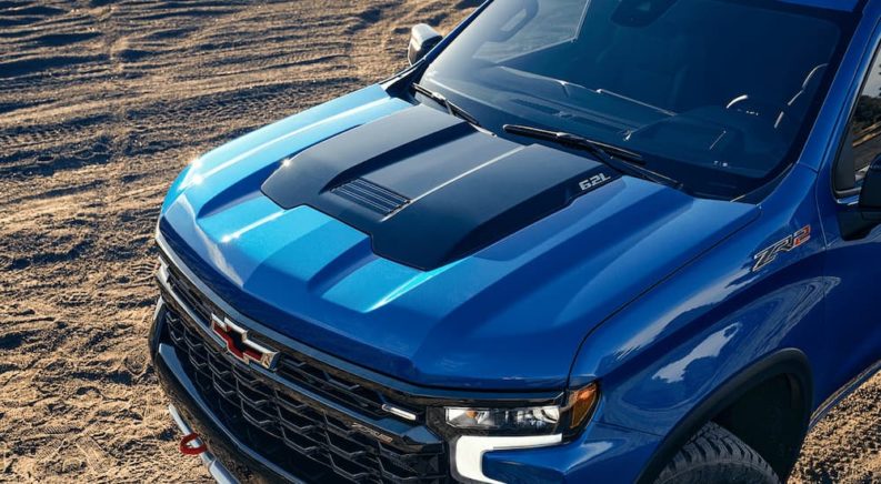 A close up of the hood of a blue 2023 Chevy Silverado 1500 ZR2 is shown after leaving a Chevy Silverado dealer.