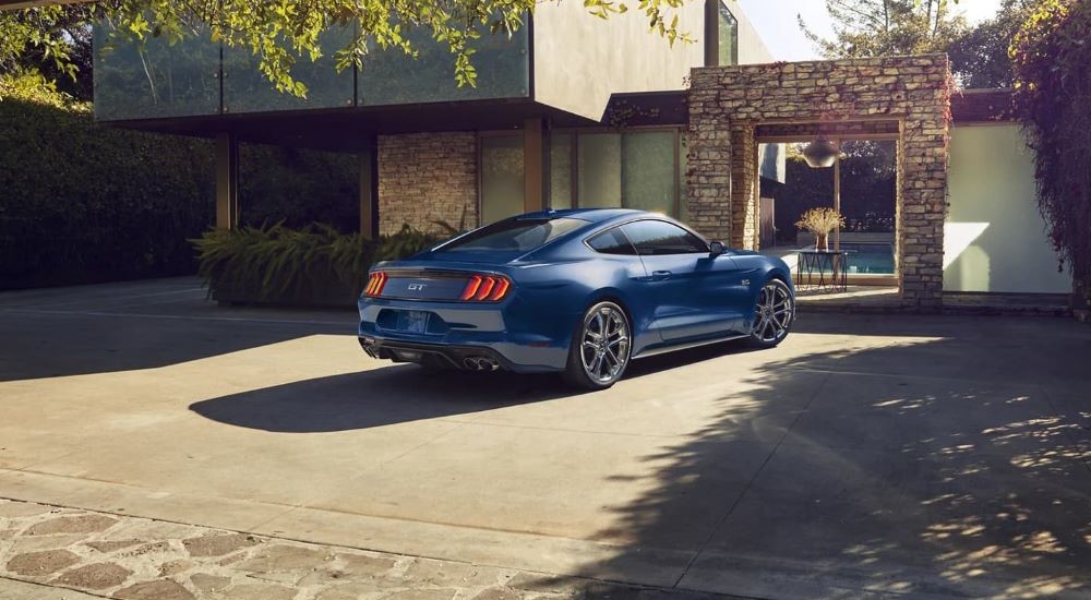 A dark blue 2023 Ford Mustang GT is shown parked in a driveway after leaving a Ford delaer. 