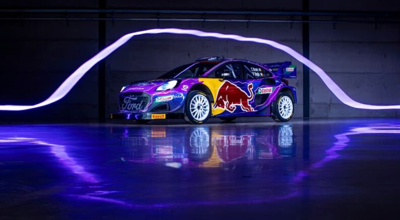 A 2022 Ford Rally1 is shown in a garage with purple lighting.