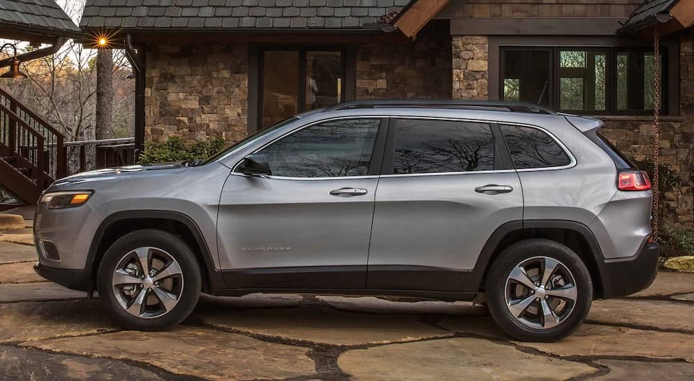 A silver 2022 Jeep Cherokee Limited is shown from the side parked in a driveway.