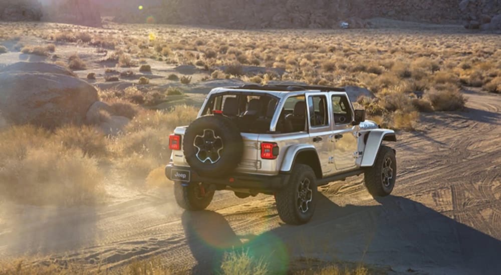 A silver 2023 Jeep Wrangler Rubicon 4xe is shown from the rear at an angle.