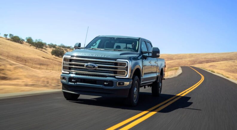 The newest Ford F-350 for sale, a black 2023 Ford Super Duty F-350 Limited, is shown driving.