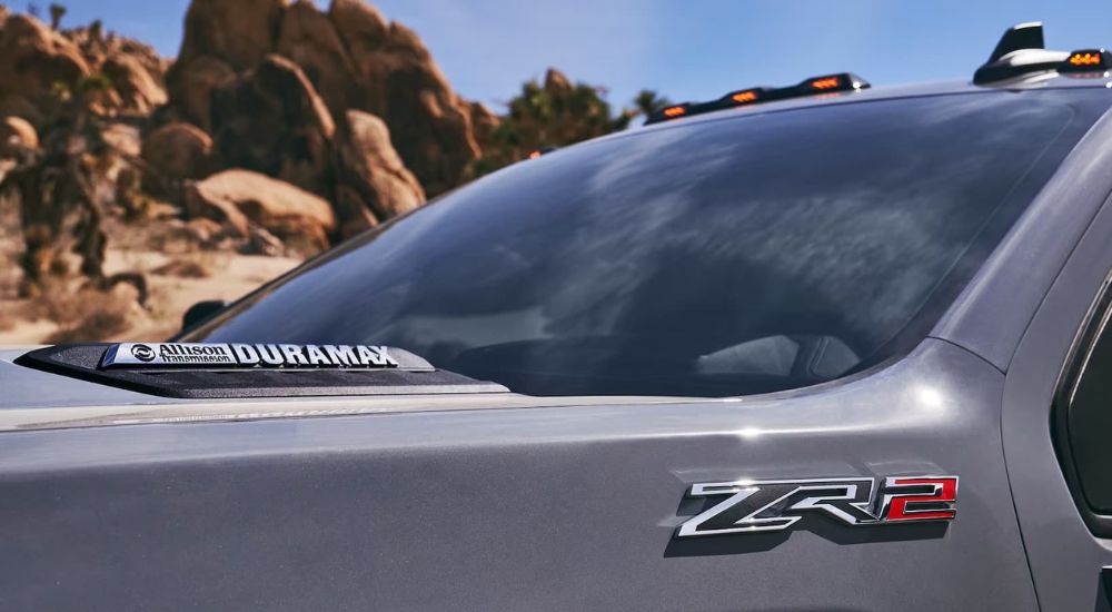 A close up of the hood of a 2024 Silverado 3500 ZR2 is shown with the tag "Allison Transmission, Duramax" clearly displayed.