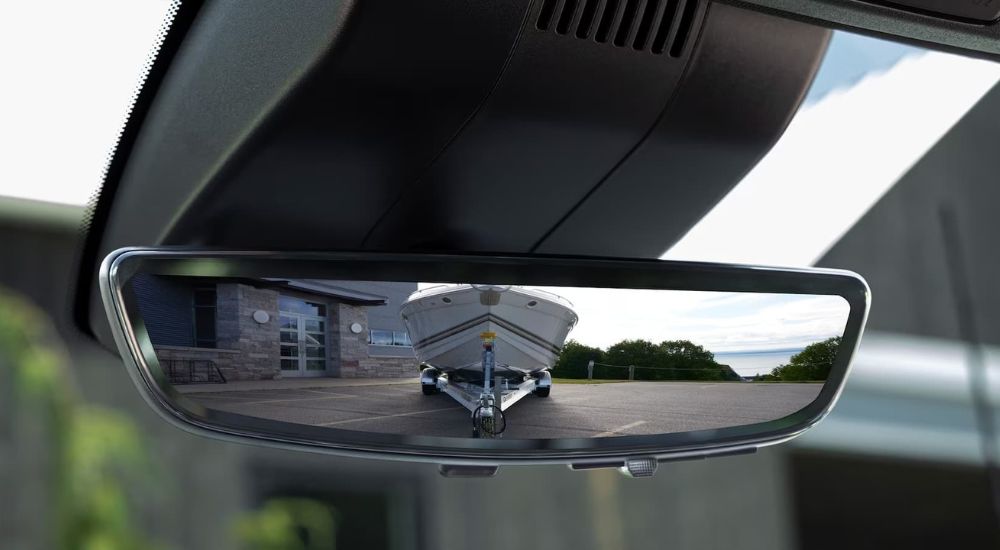 The rearview camera mirror with a view of a boat being towed is shown. 
