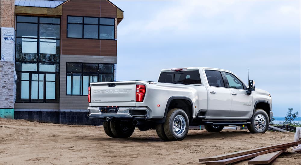 A silver 2024 Chevy Silverado 3500 HD is shown from the rear at an angle.