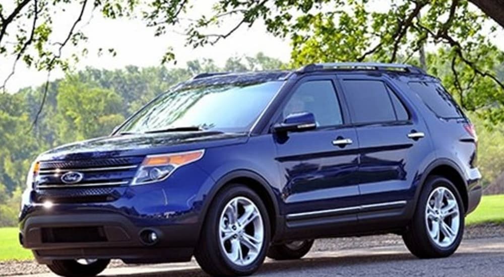 A blue 2011 Ford Explorer for sale is shown parked under a tree.