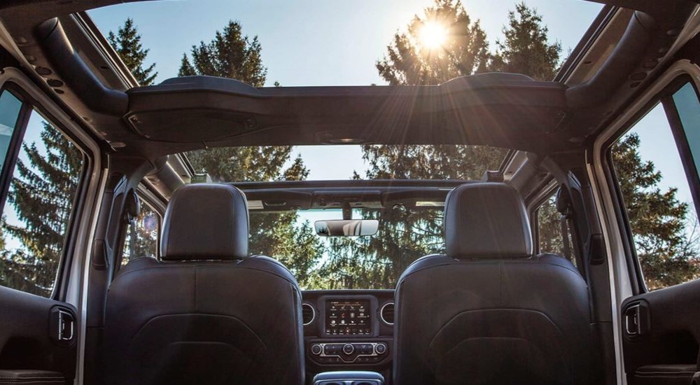 The sun is shining through the sunroof of a 2023 Jeep Wrangler.