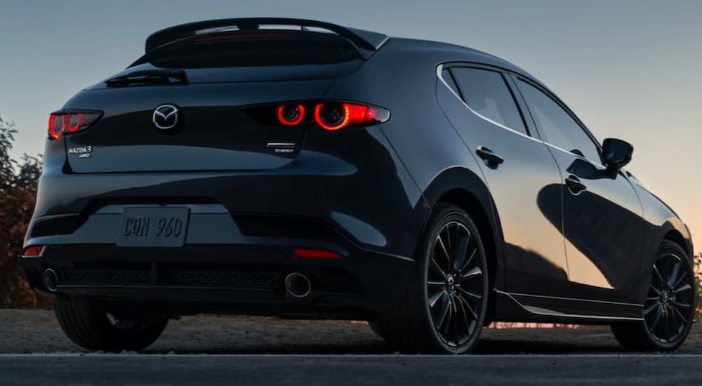  A black 2021 Mazda3 Turbo hatchback is shown from the rear.