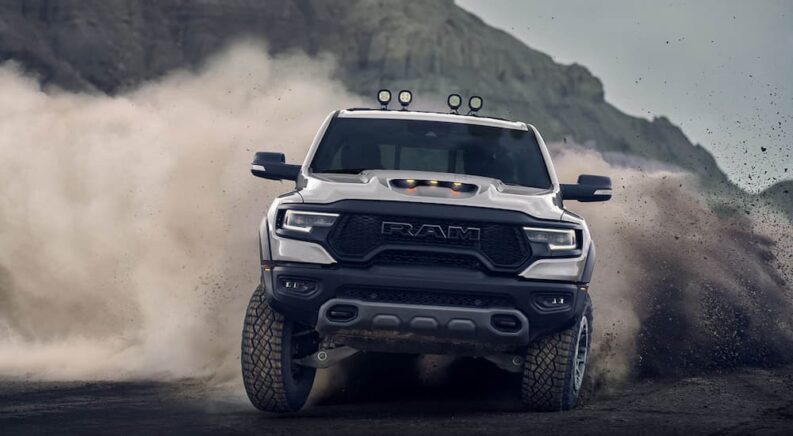 A white 2022 Ram 1500 TRX, a popular Ram truck for sale, is shown off-roading.