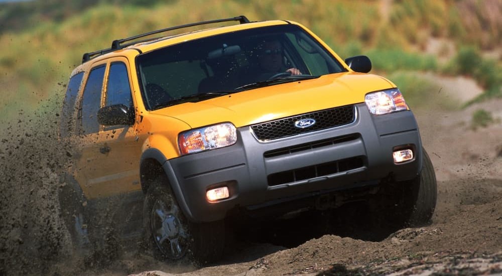 A yellow 2001 Ford Escape is shown on a dirt path after leaving a used Ford dealership.