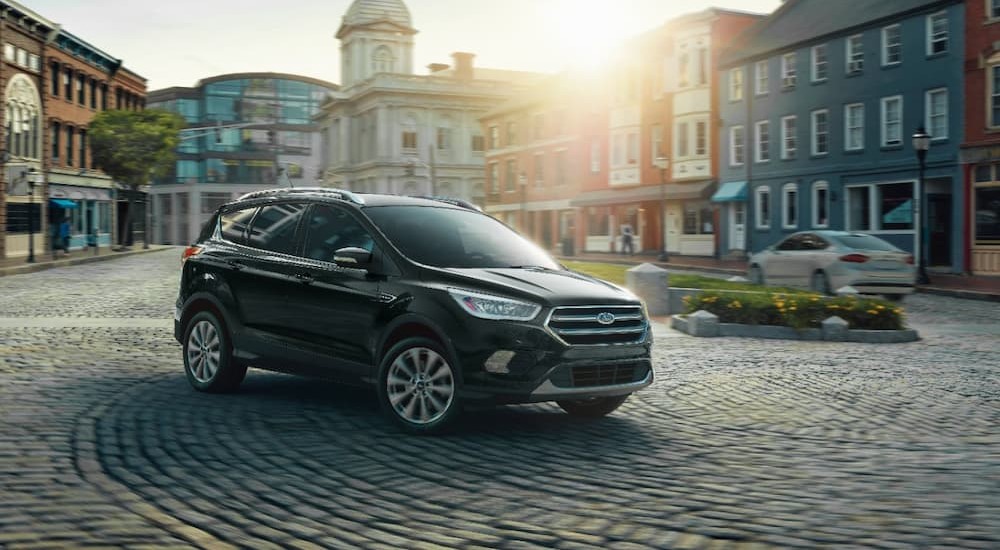 A black 2019 Ford Escape Titanium is shown parked in a city.