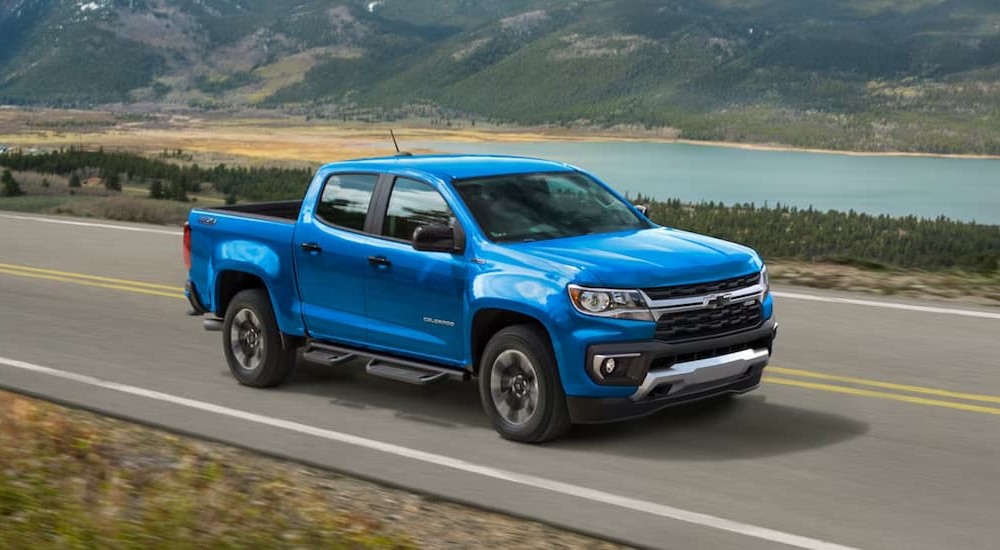 A blue 2022 Chevy Colorado is shown driving on a highway.