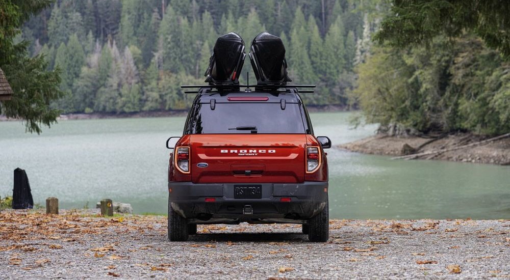 A red 2023 Ford Bronco Sport is shown parked near a lake.
