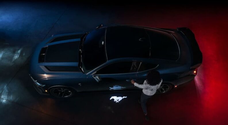 A dark blue and black 2024 Ford Mustang Dark Horse is shown parked from an aerial view.