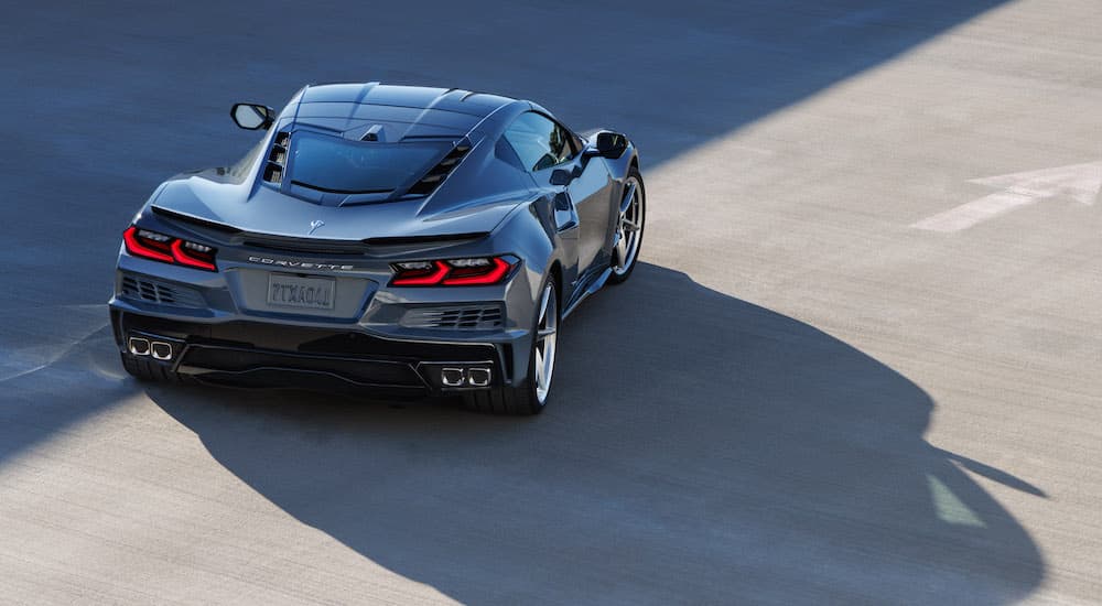 A grey 2024 Chevy Corvette E-Ray is shown from the rear at an angle.