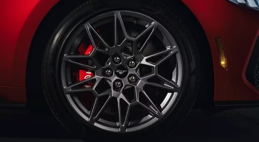 The wheel of a red 2024 Ford Mustang is shown.