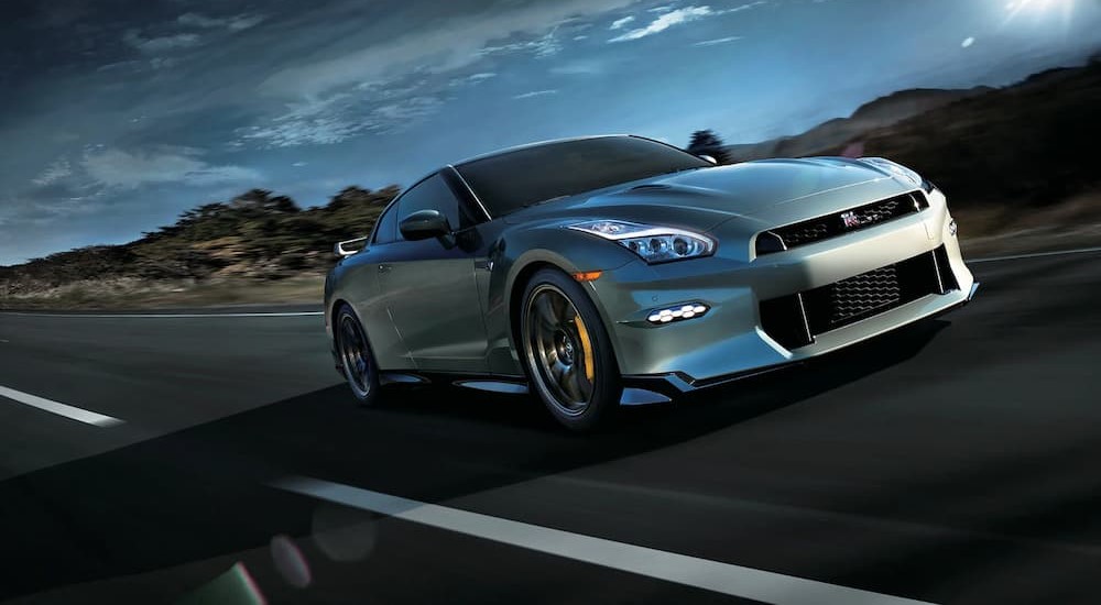A silver 2024 Nissan GT-R is shown driving on a highway after visiting a Nissan dealer.