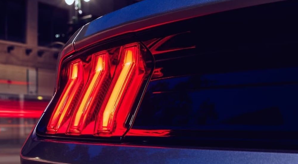 The tail light of a blue 2023 Ford Mustang is shown.