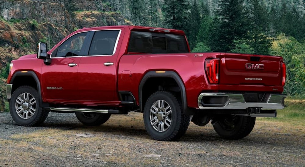A red 2020 GMC Sierra 3500 HD is shown parked near a forest.