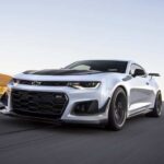 A white 2019 Chevy Camaro ZL1 is shown from the front at an angle.