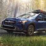 A blue 2023 Subaru Outback Onyx Edition is shown off-roading after winning a 2023 Subaru Outback vs 2023 Volkswagen Atlas Cross Sport comparison.