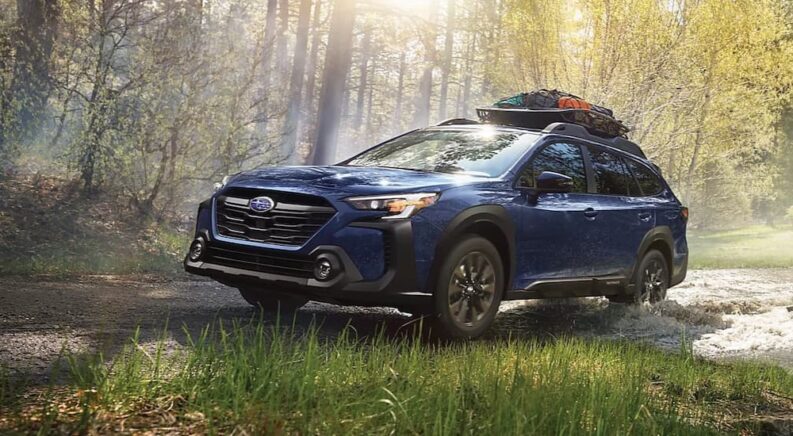 A blue 2023 Subaru Outback Onyx Edition is shown off-roading after winning a 2023 Subaru Outback vs 2023 Volkswagen Atlas Cross Sport comparison.