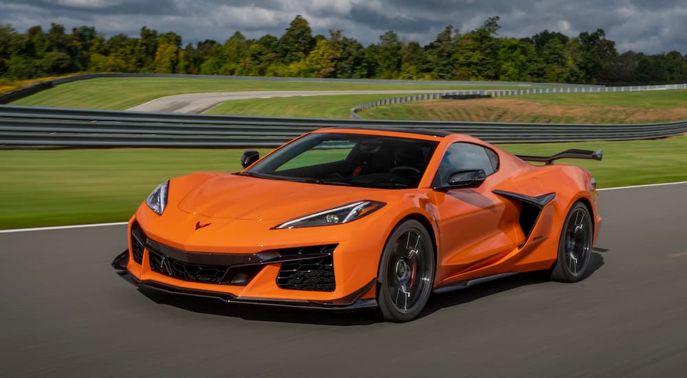 An orange 2023 Chevy Corvette Z06 is shown from the front at an angle.