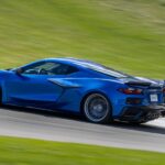 A blue 2023 Chevy Corvette Z06 is shown from the side on a racetrack.
