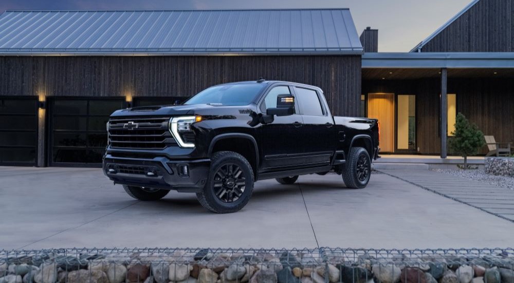 A black 2024 Chevy Silverado 2500 HD High Country Midnight Edition is shown parked on a driveway.