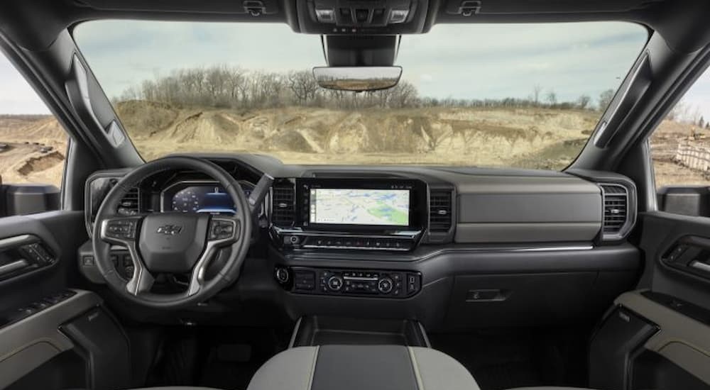 The black and gray interior and dash of a 2024 Chevy Silverado 2500 HD is shown.