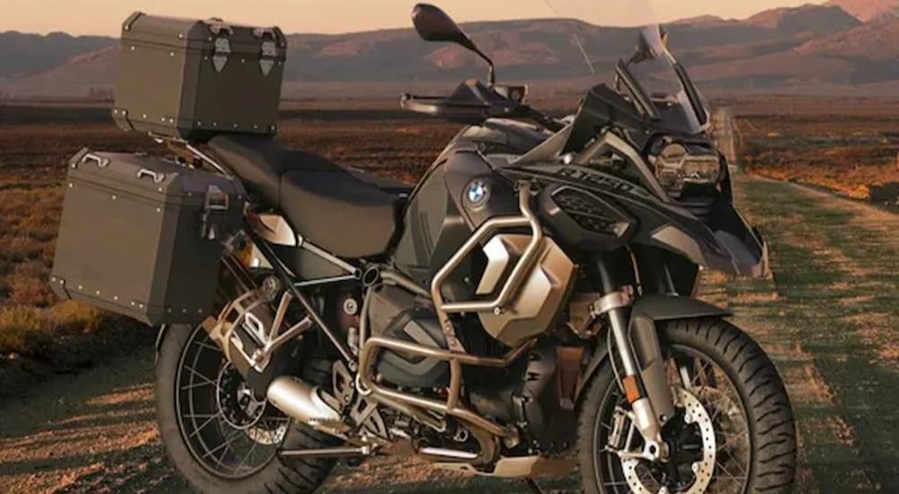 A dark green BMW R 1250 GS Adventure is shown parked on a road.