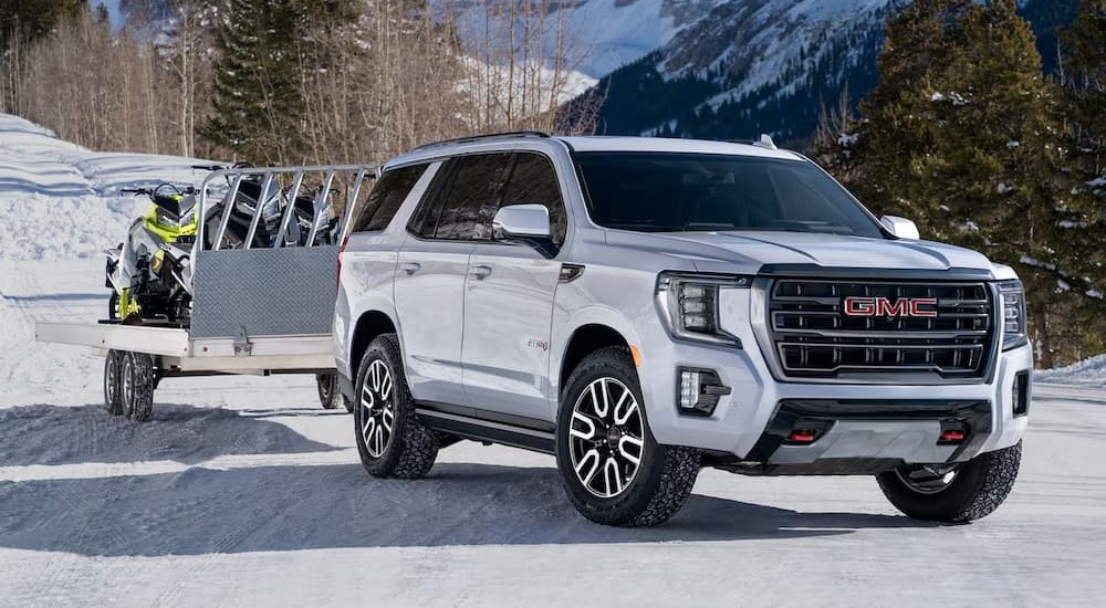 A white 2023 GMC Yukon AT4 is shown parked on snow.