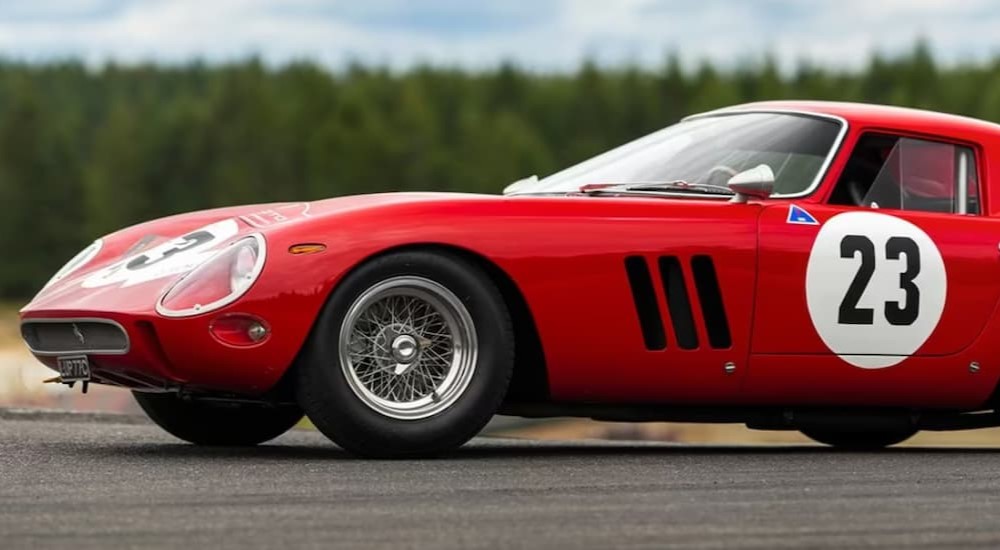 A red 1962 Ferrari 250 GTO is shown parked on cement.