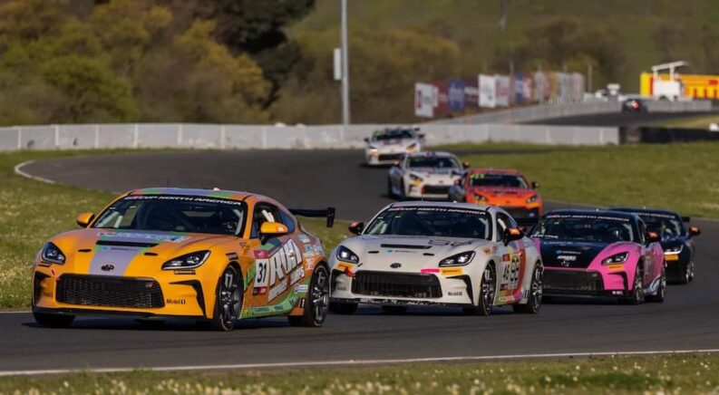 A group of Toyota GR cup cars are shown racing on Sonoma raceway.